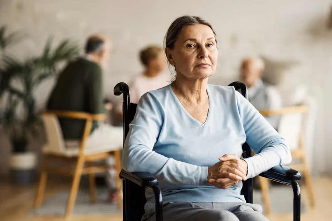 Photo of a woman wearing a baby blue top in a wheelchair