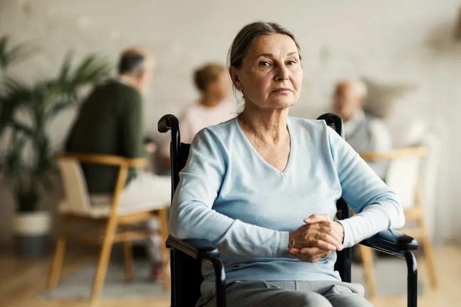 Photo of a woman wearing a baby blue top in a wheelchair