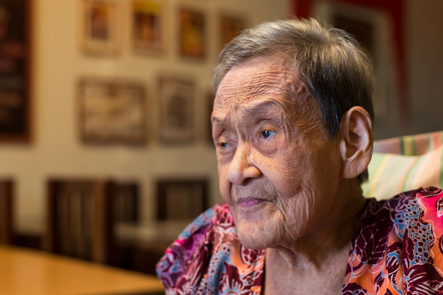 Photograph of a senior person wearing a richly patterned blouse