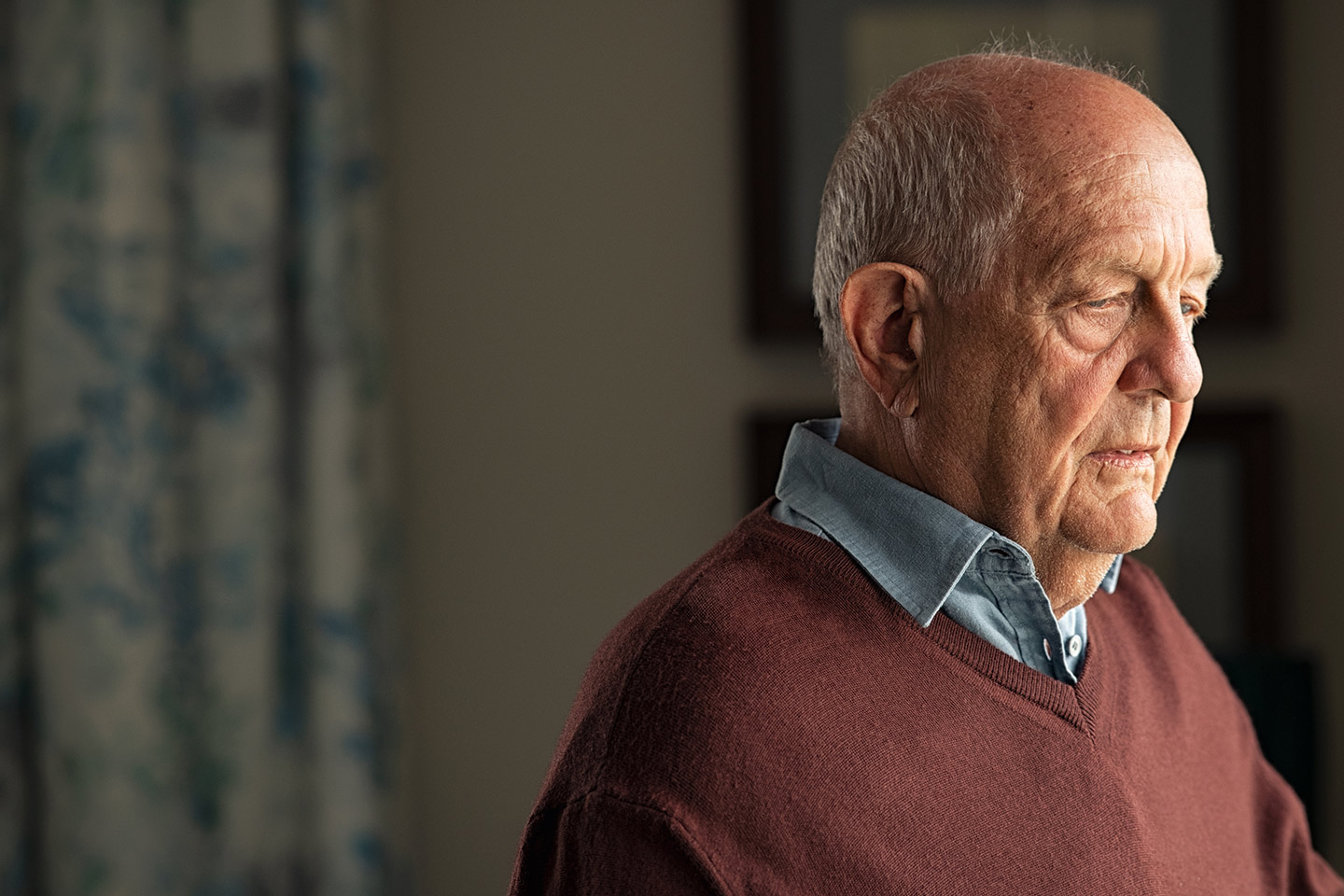 Photo of a man in a brown jumper and chambray shirt