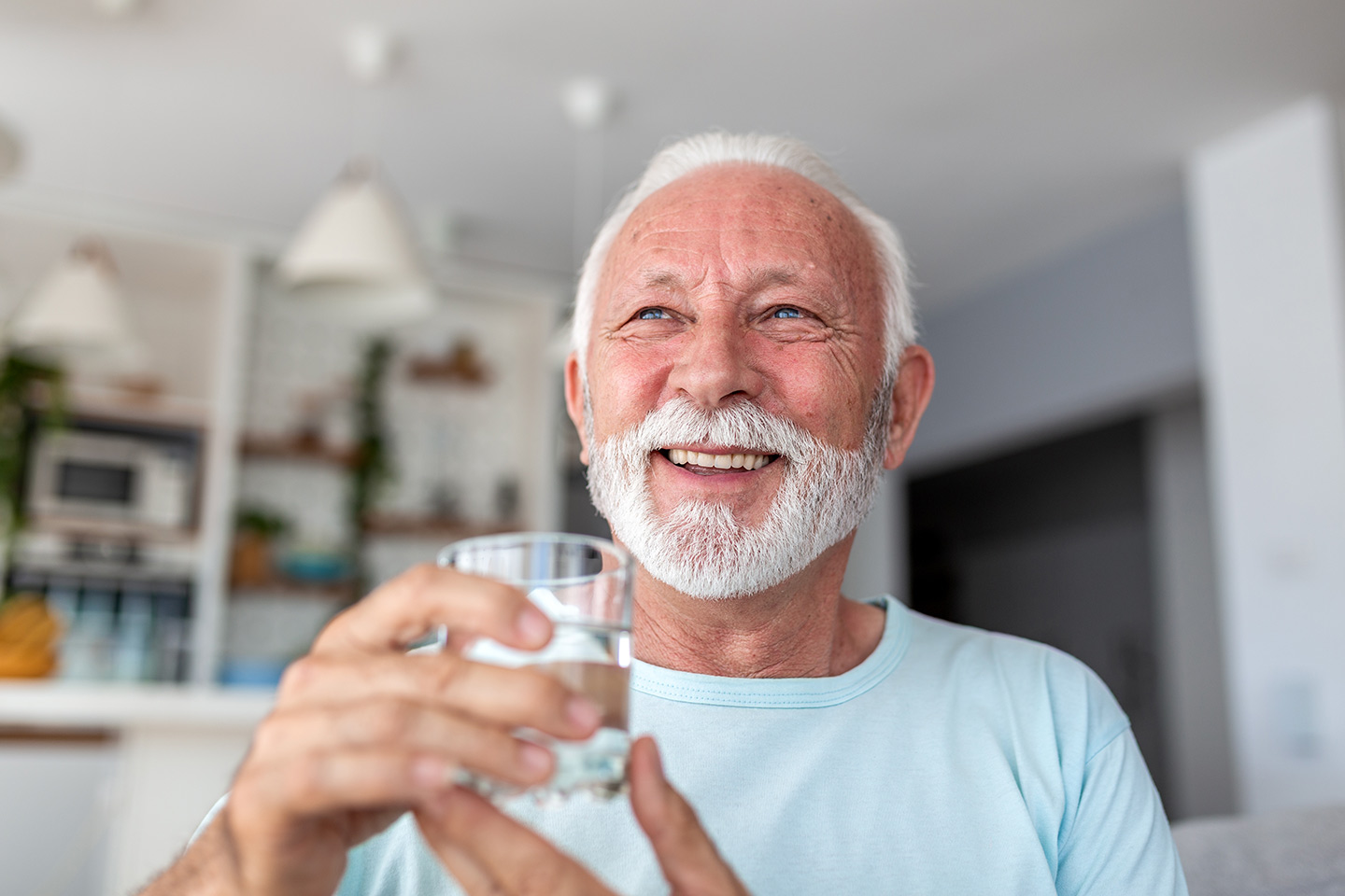 Image of an older man holding a glass of water