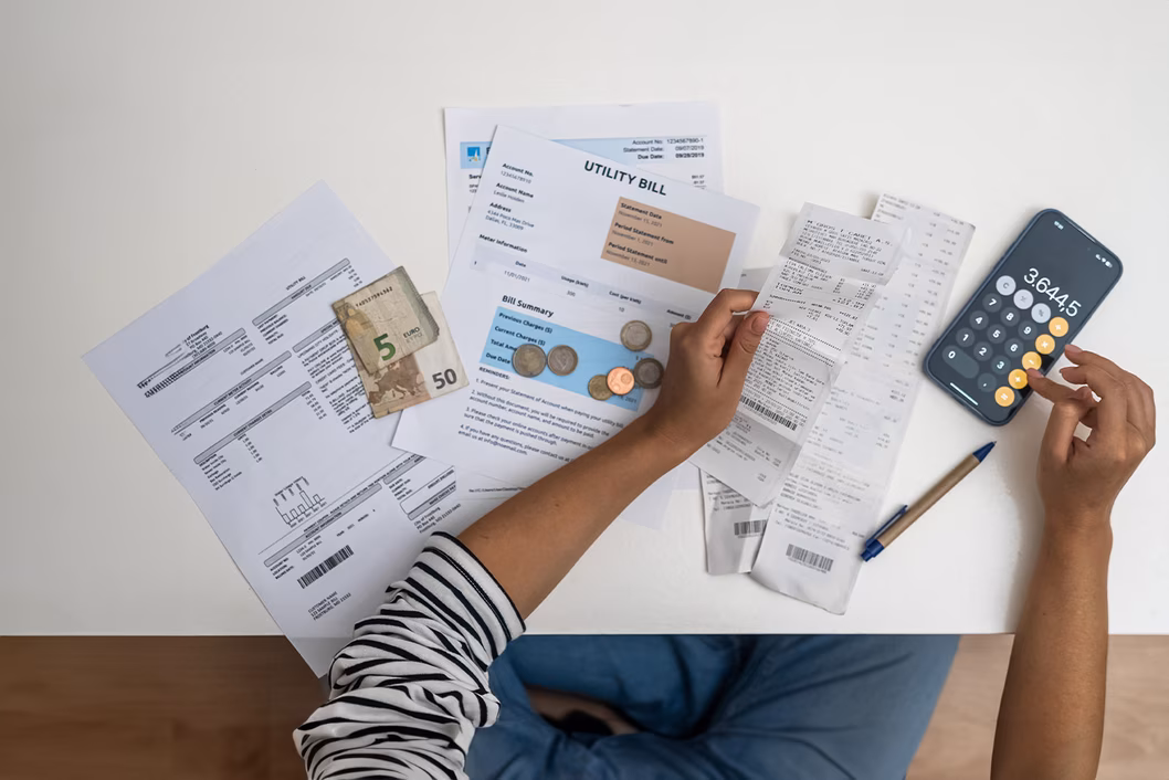Photo of someone budgeting with bills and calculator