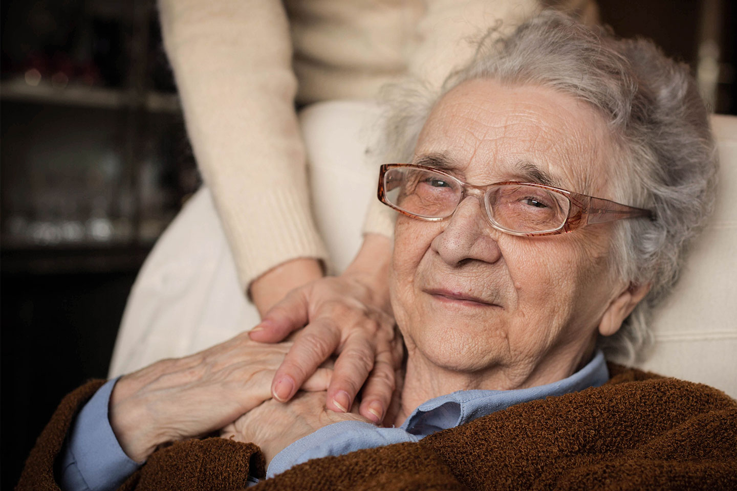 Photo of an older woman holding the hands of another person