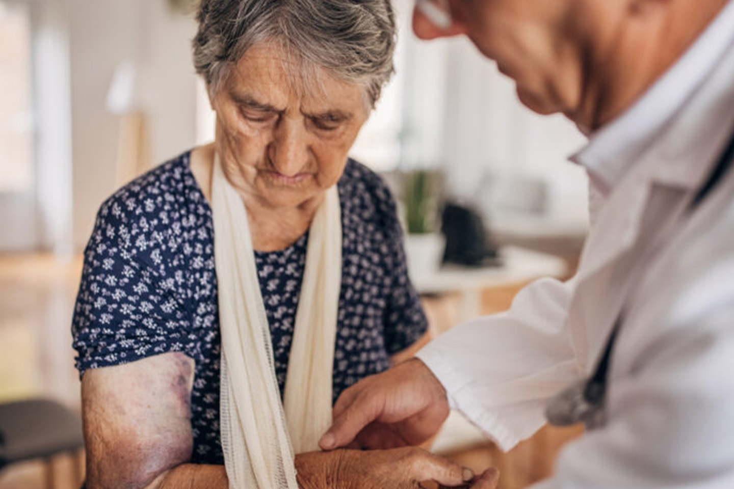 Image of an older woman in hospital being treated for an arm injury