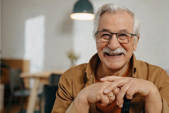 Foto de un hombre riendo con una camisa marrón
