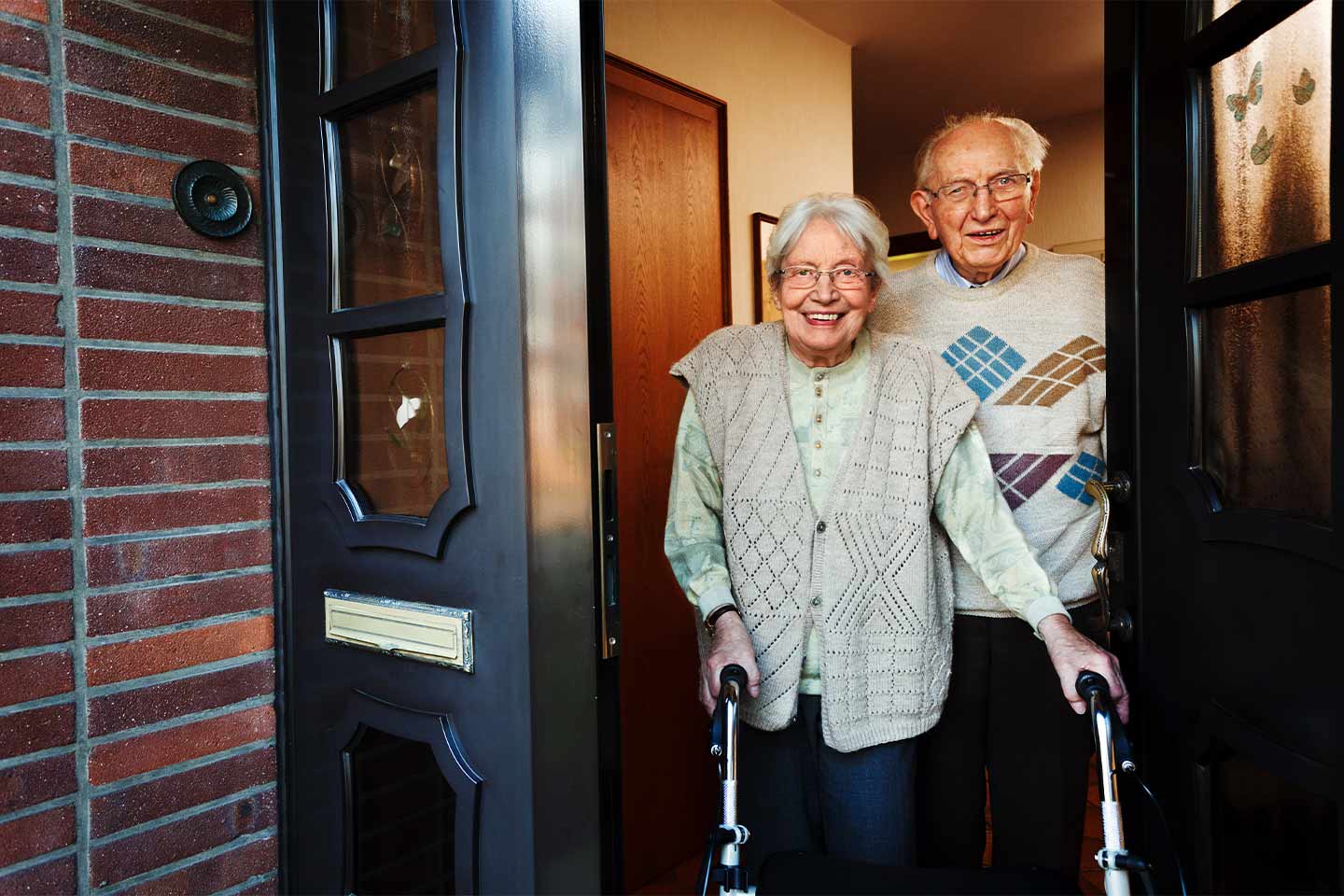 Photo of older couple smiling in doorway