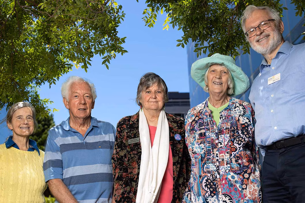 Photo of a group of people outdoors smiling for the camera