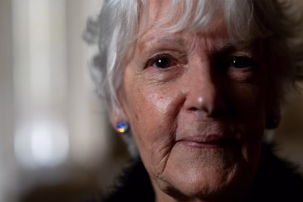 Photo of a woman with sparkly earrings in a poorly lit room