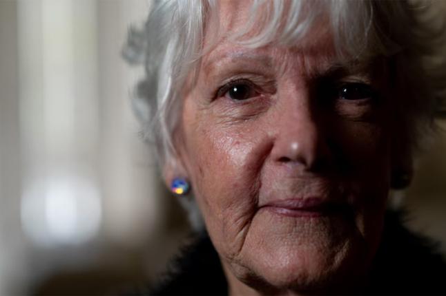 Photo of a woman with sparkly earrings in a poorly lit room