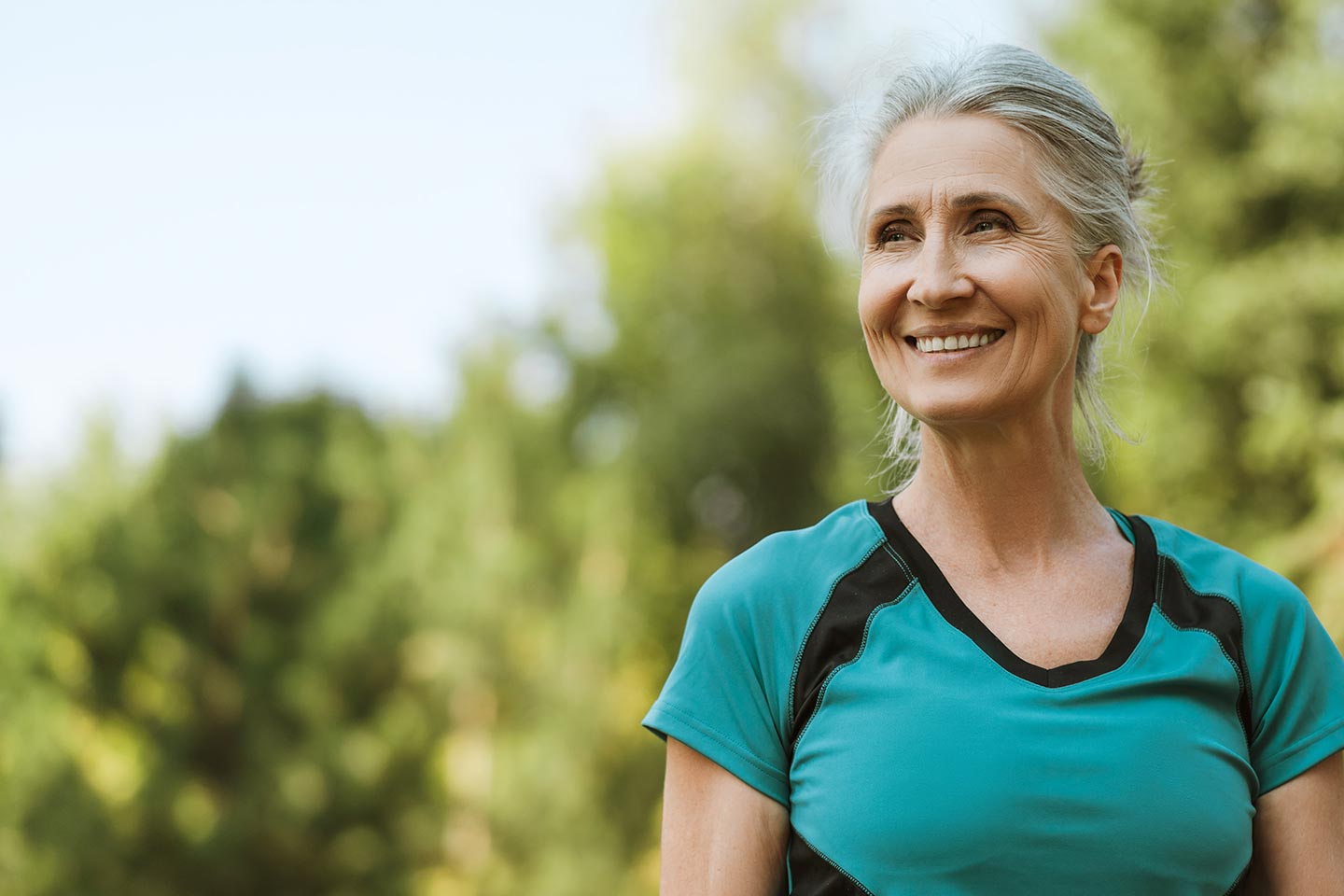 Woman in a park wearing teal and black t shirt