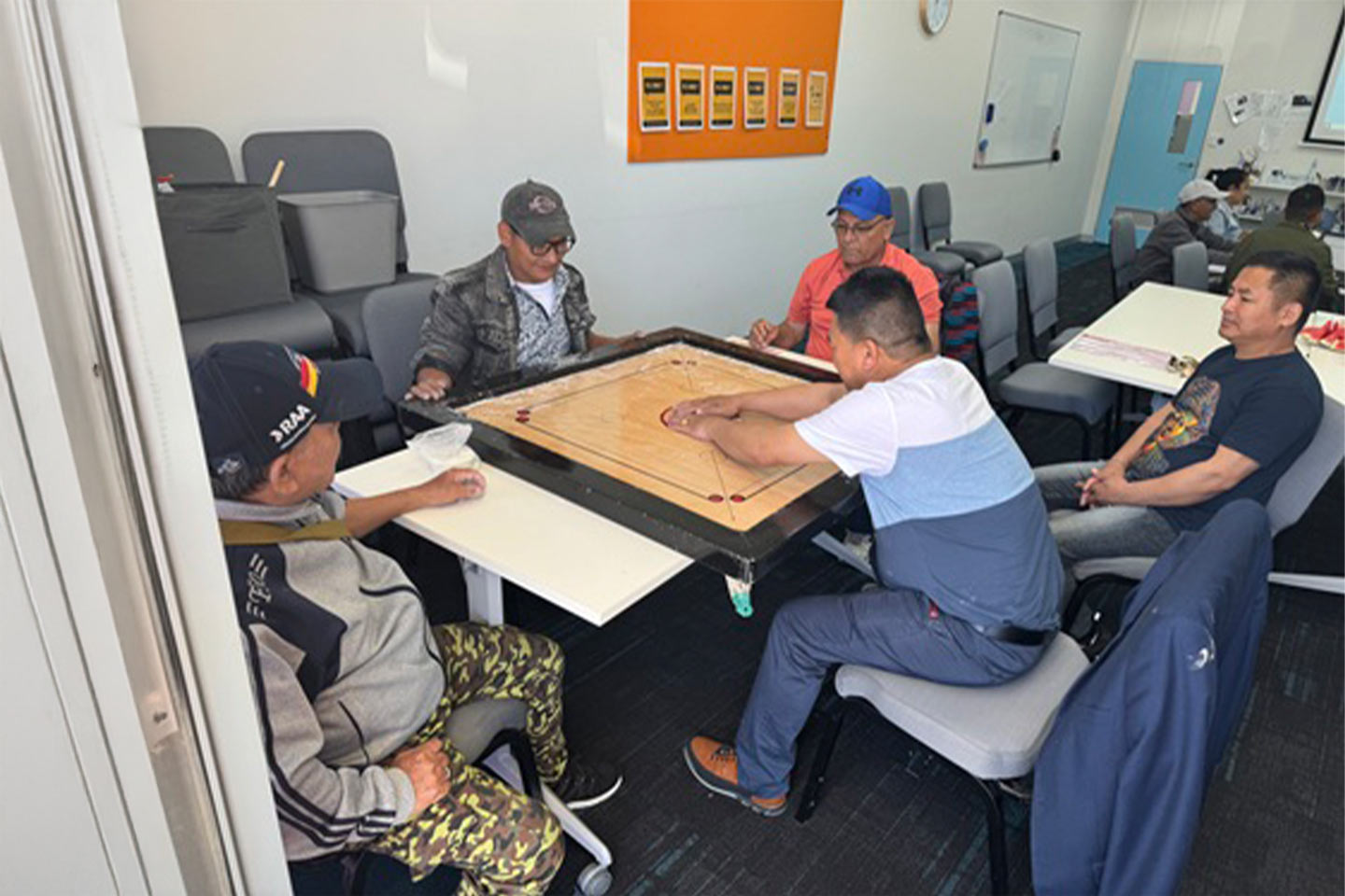 Group of people playing a boardgame around a table