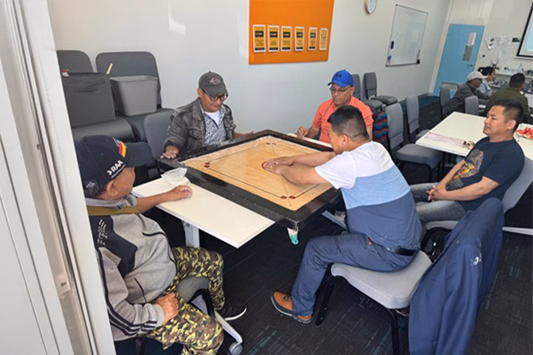 Group of people playing a boardgame around a table