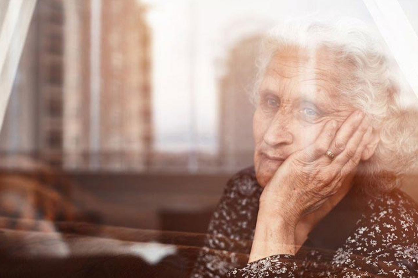 Photo of older lady looking pensively through a window
