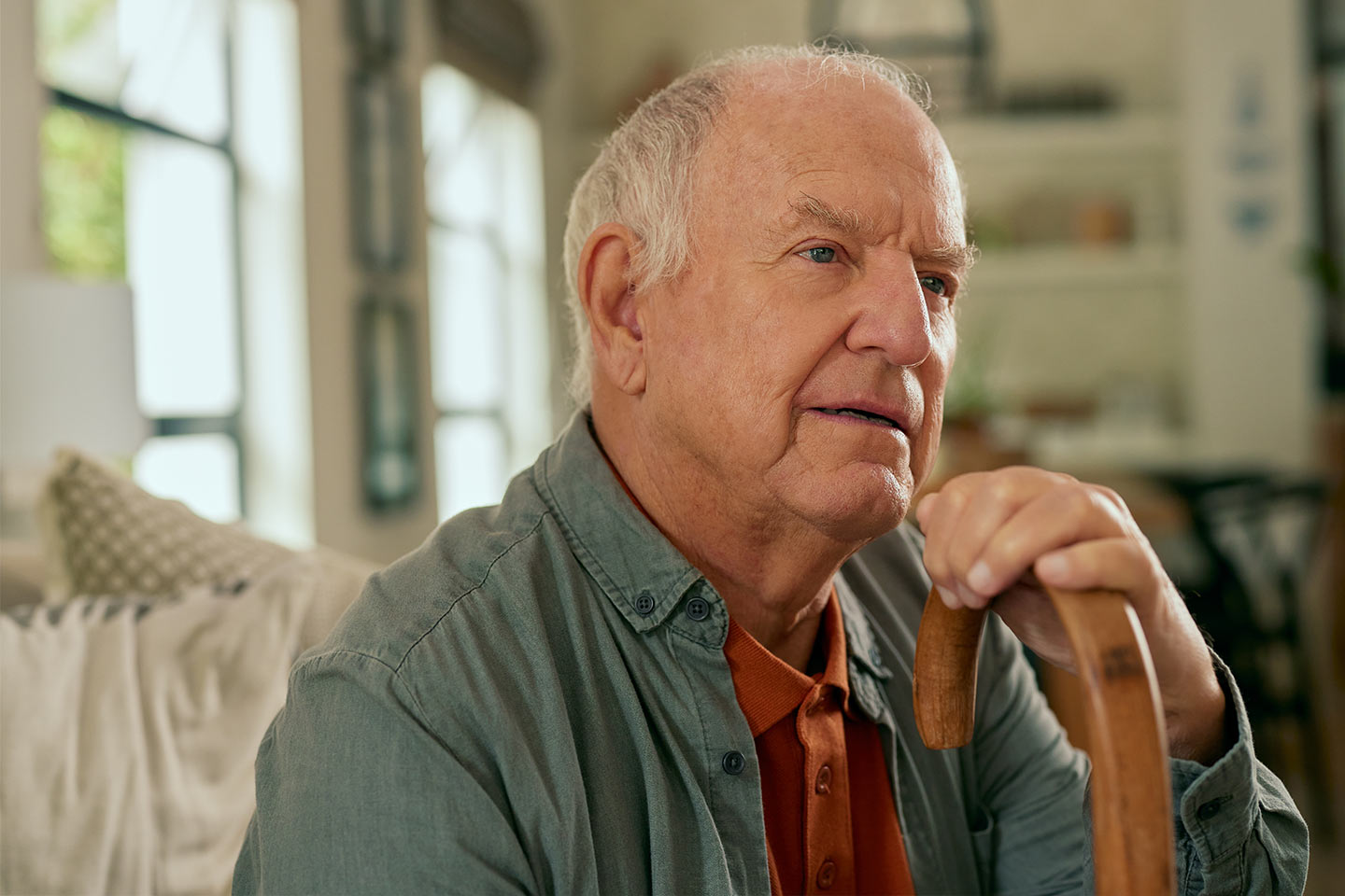 Photo of a man seated with his walking stick