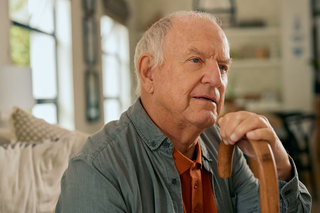 Photo of a man seated with his walking stick