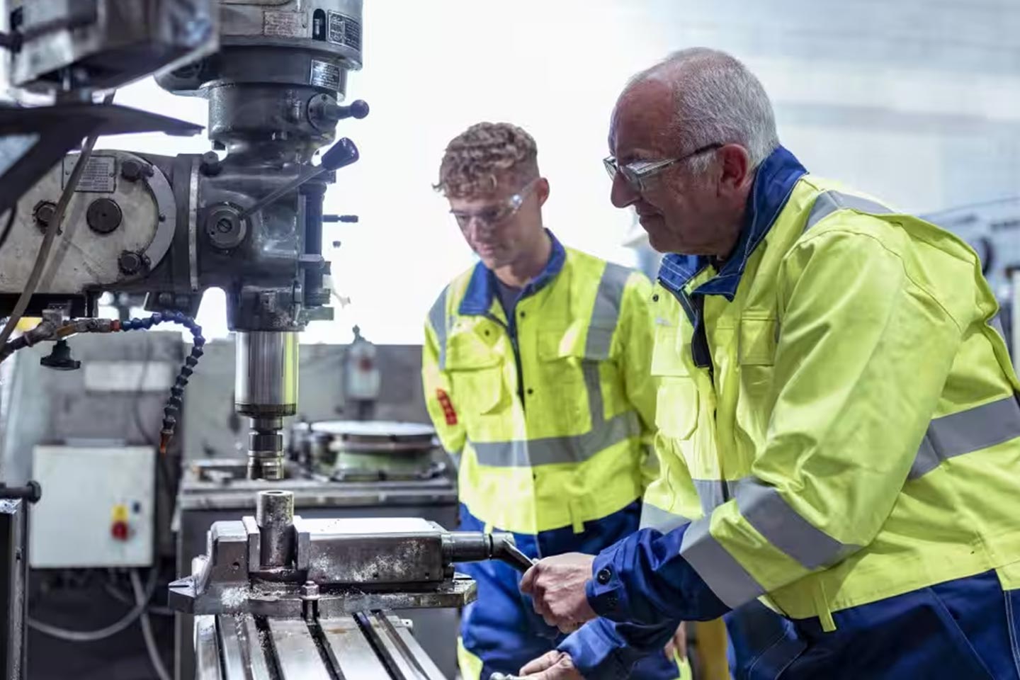 Photo of two men wearing high vis at an engineering plant
