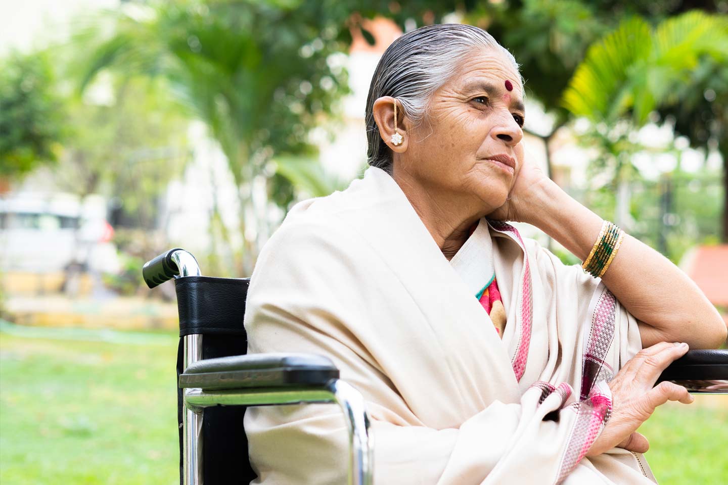 Photo of a woman sitting in a wheelchair in a park