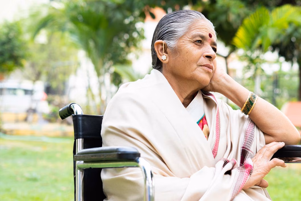 Photo of a woman sitting in a wheelchair in a park