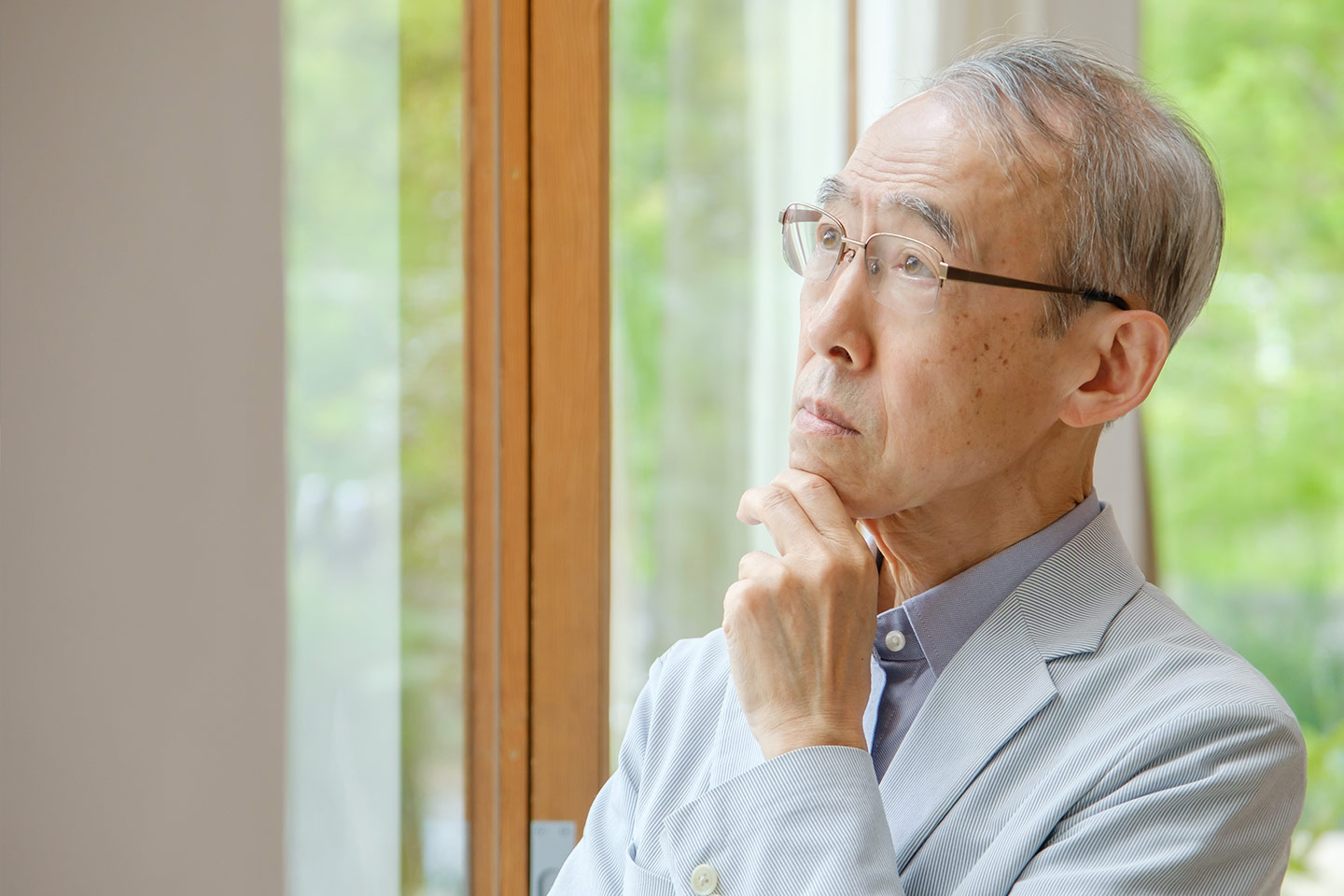 Photo of a man pondering something with his hand on his chin