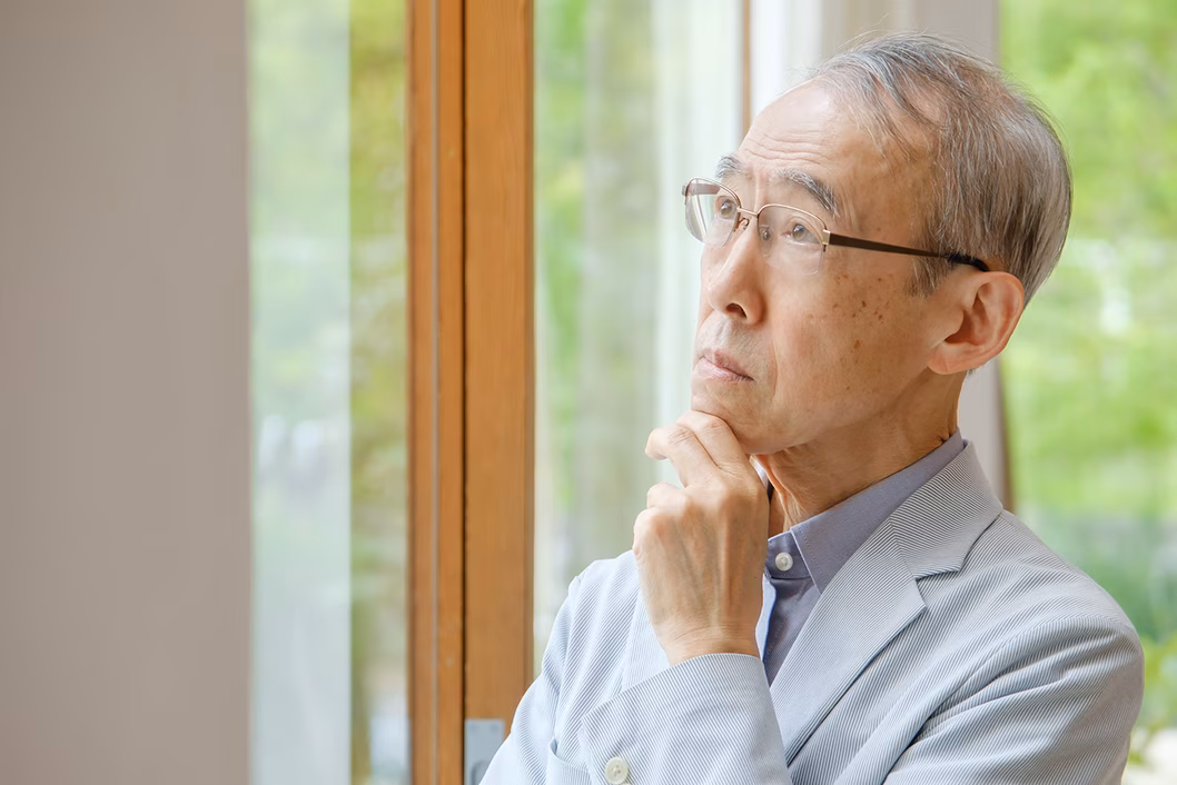 Photo of a man pondering something with his hand on his chin