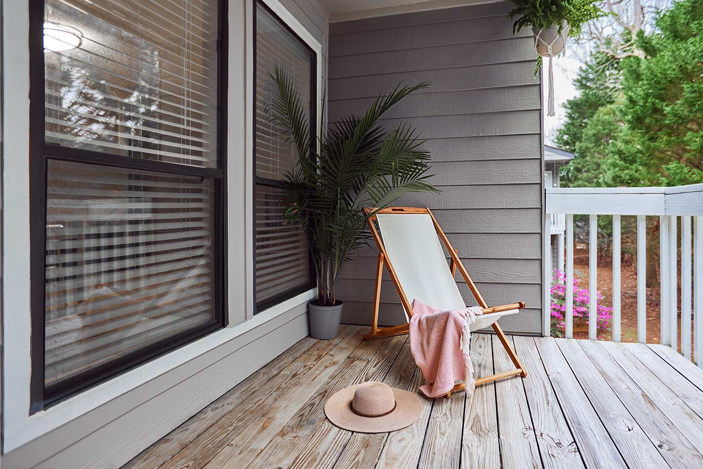 Photo of a deckchair, pink throw, and straw hat on a deck