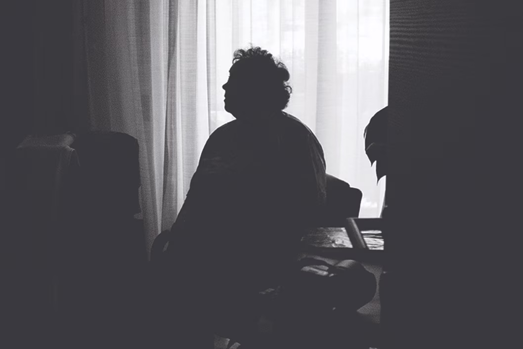 Image of older person sitting in the dark
