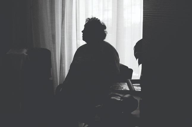 Image of older person sitting in the dark