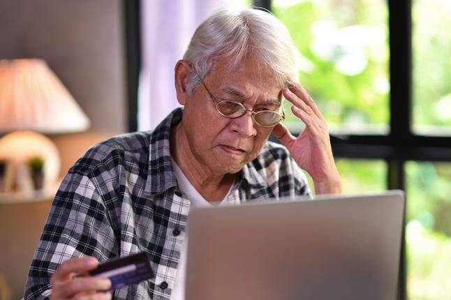 Hình ảnh một người đàn ông lớn tuổi đang nhìn vào máy tính xách tay