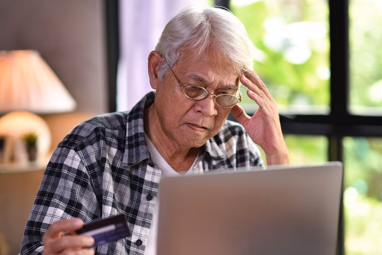 Image of an older man looking at a laptop