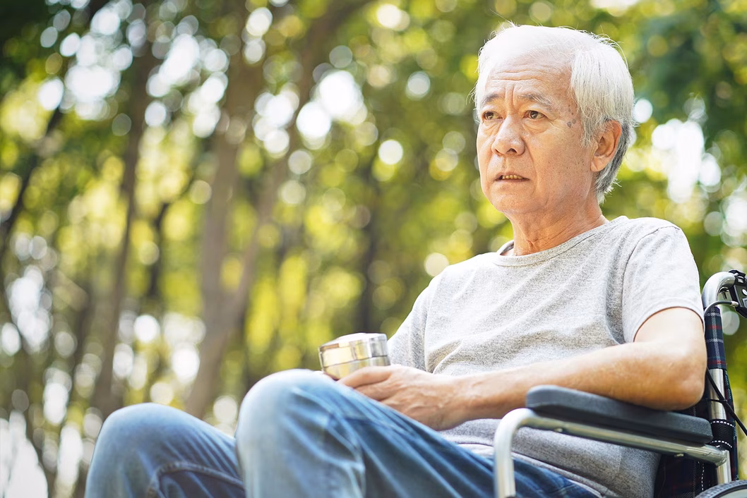 Photo of a sad looking man sitting in a wheelchair