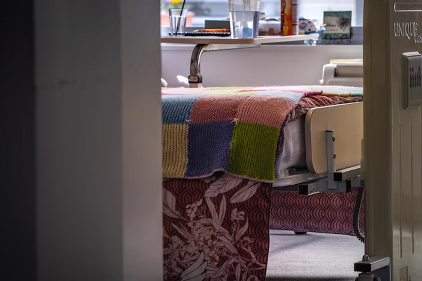 Photo of a knitted blanket at the end of a hospital bed