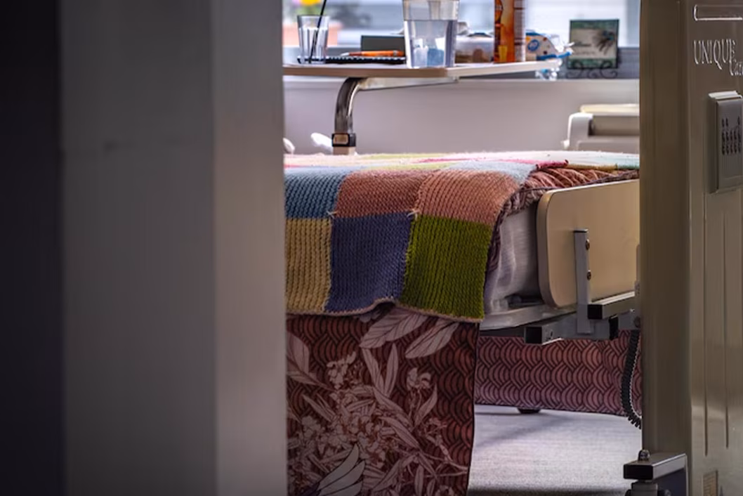 Photo of a knitted blanket at the end of a hospital bed