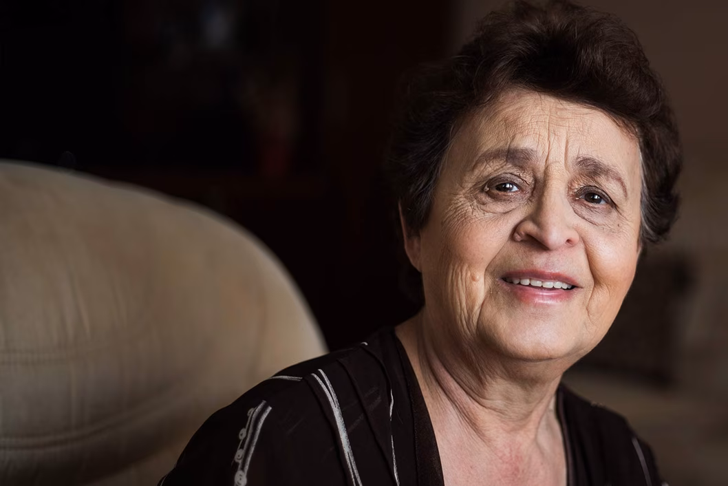 Photo of woman smiling on a taupe sofa