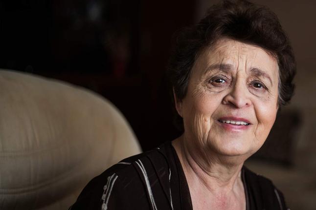 Photo of woman smiling on a taupe sofa