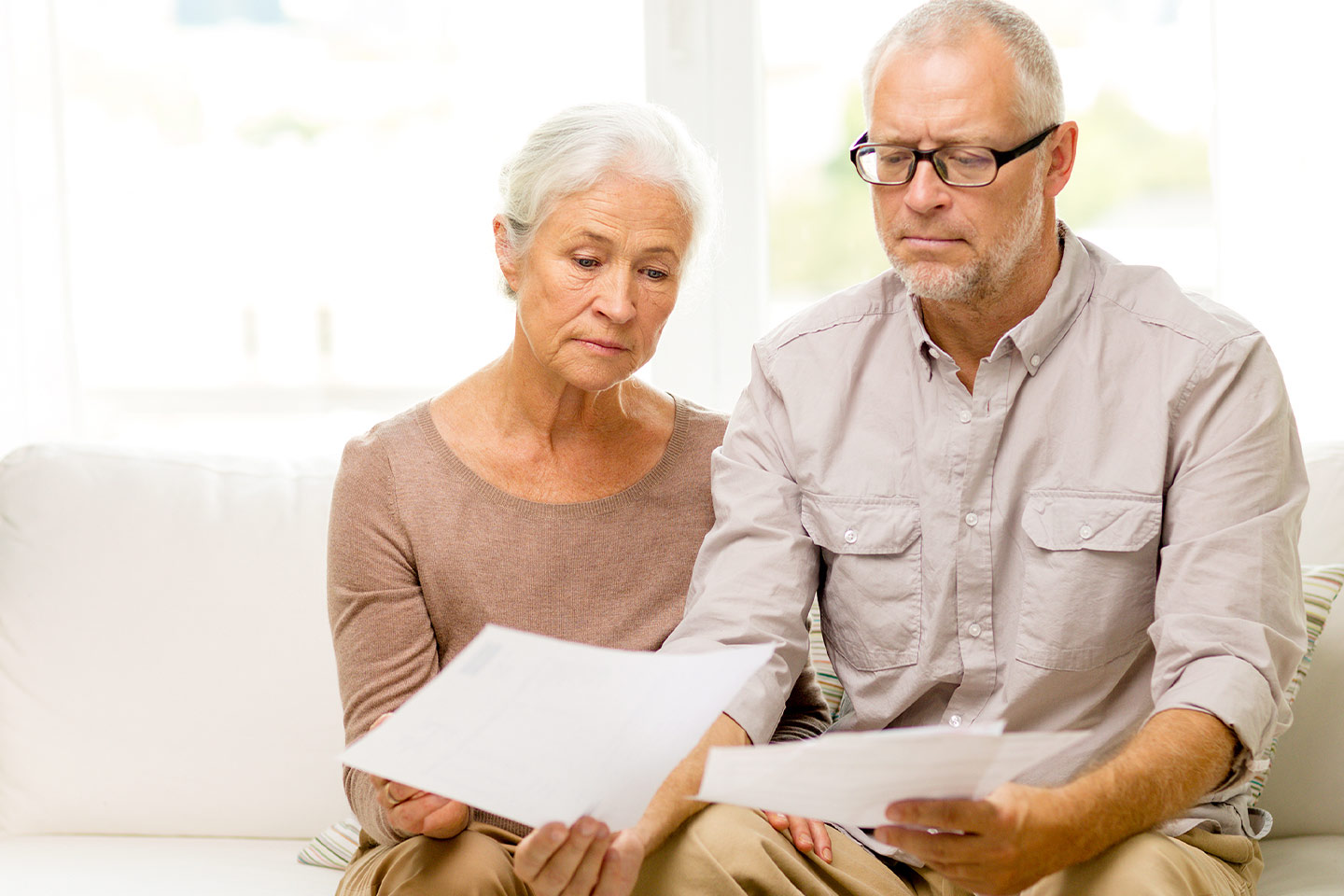 Photo of a couple sitting on a sofa looking at paperwork