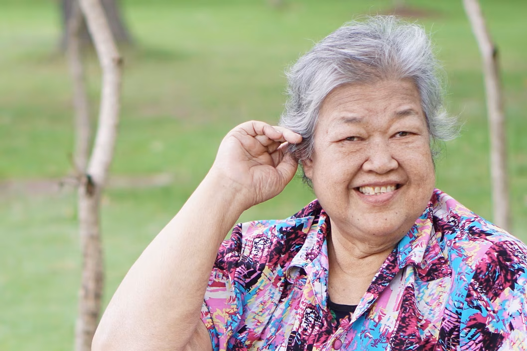 Photo of a woman in a blue and purple shirt smiling outdoors