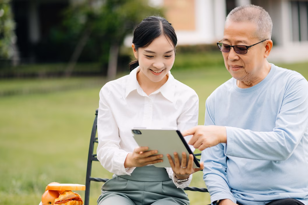 Photo of young woman and senior man seated together