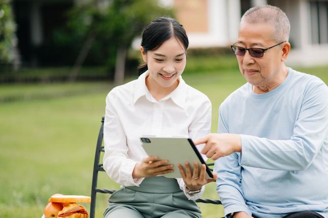 Photo of young woman and senior man seated together