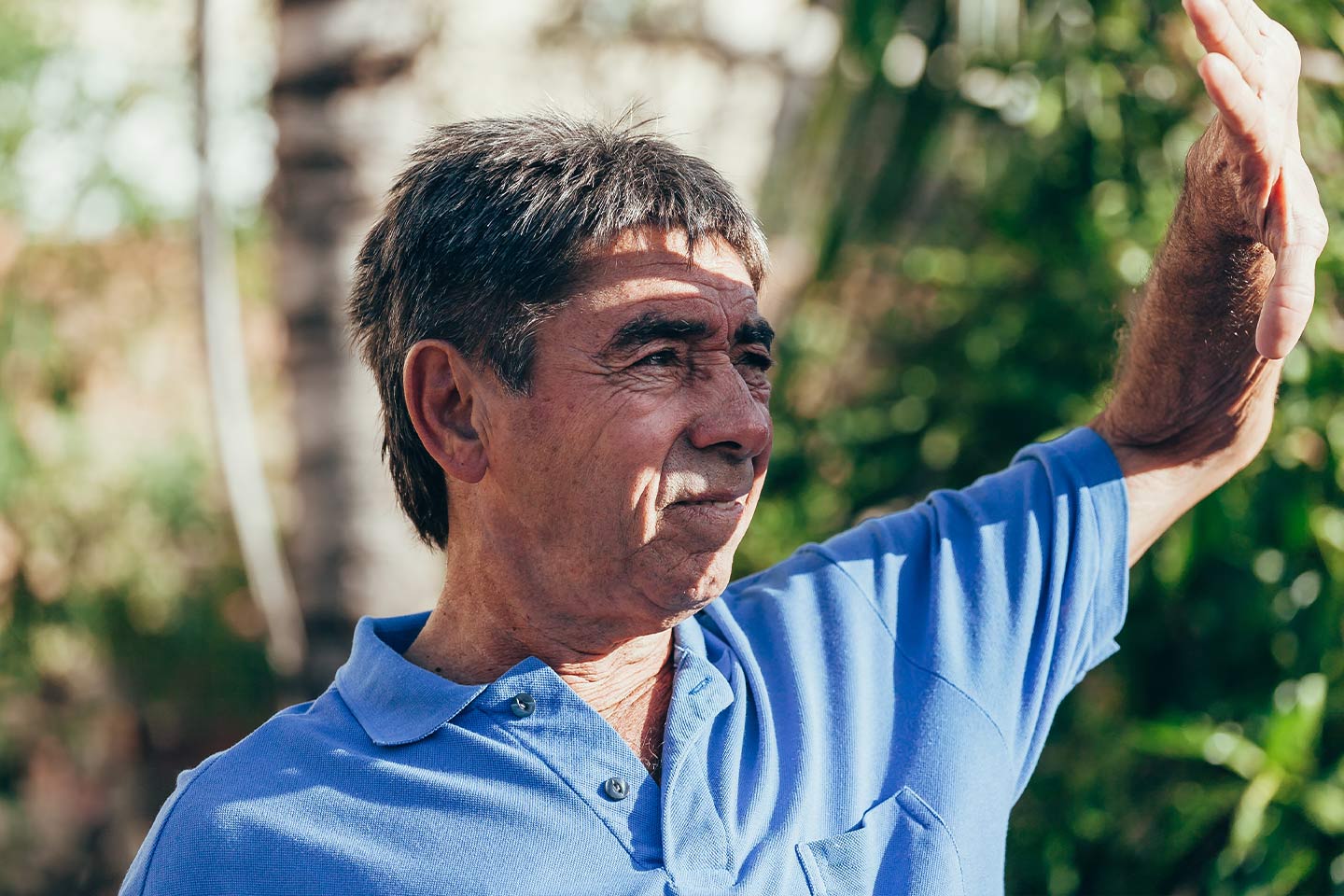 Photo of a man shielding his face from the sun with his hand