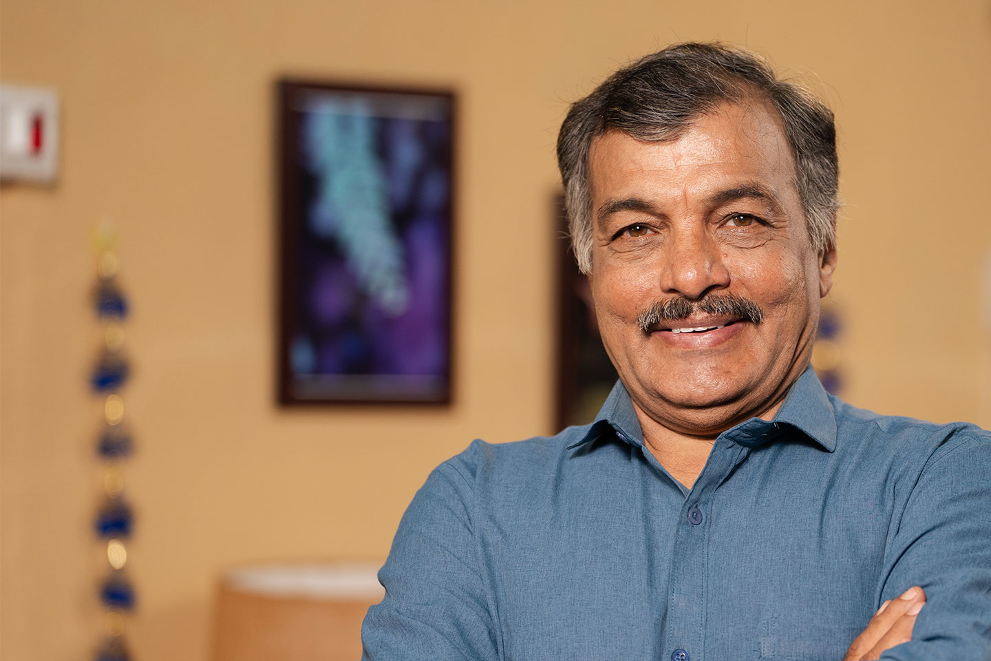 Photo of a smiling man in a blue grey shirt