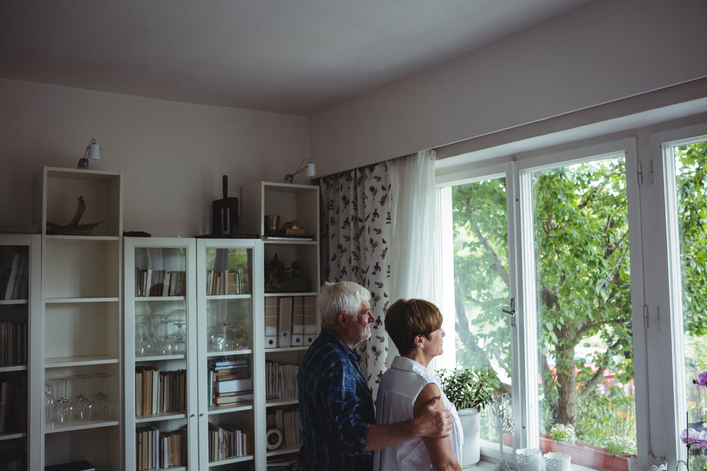 Senior couple looking through window