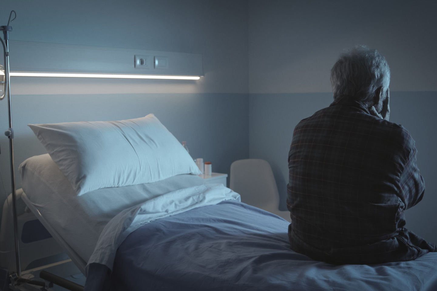 Photo of elderly patient sitting on hospital bed