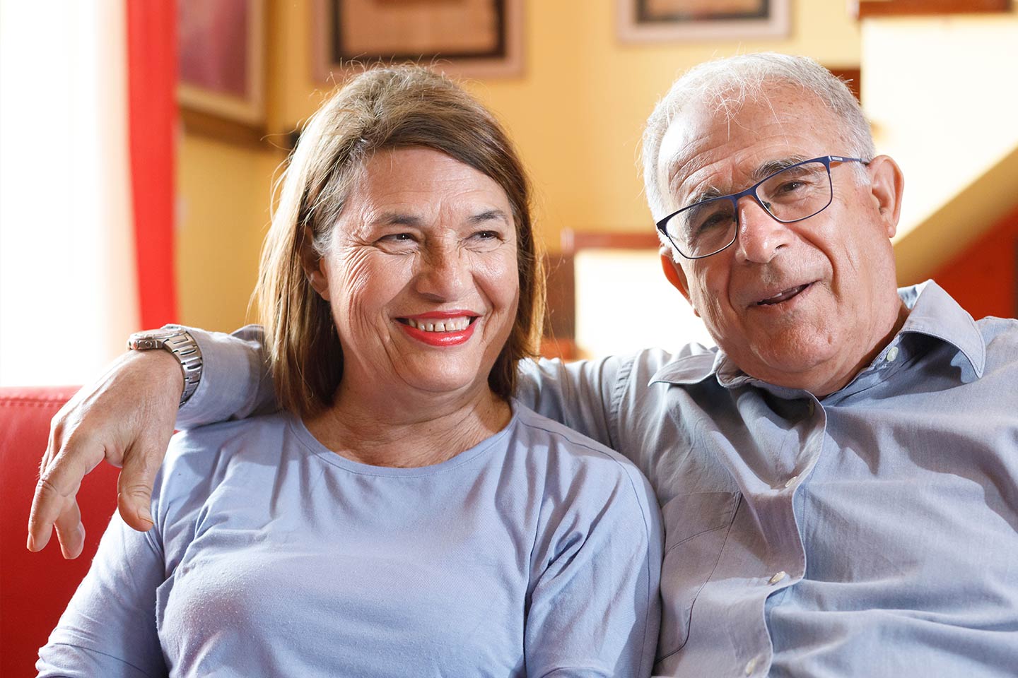Photo of two happy people sitting on a sofa