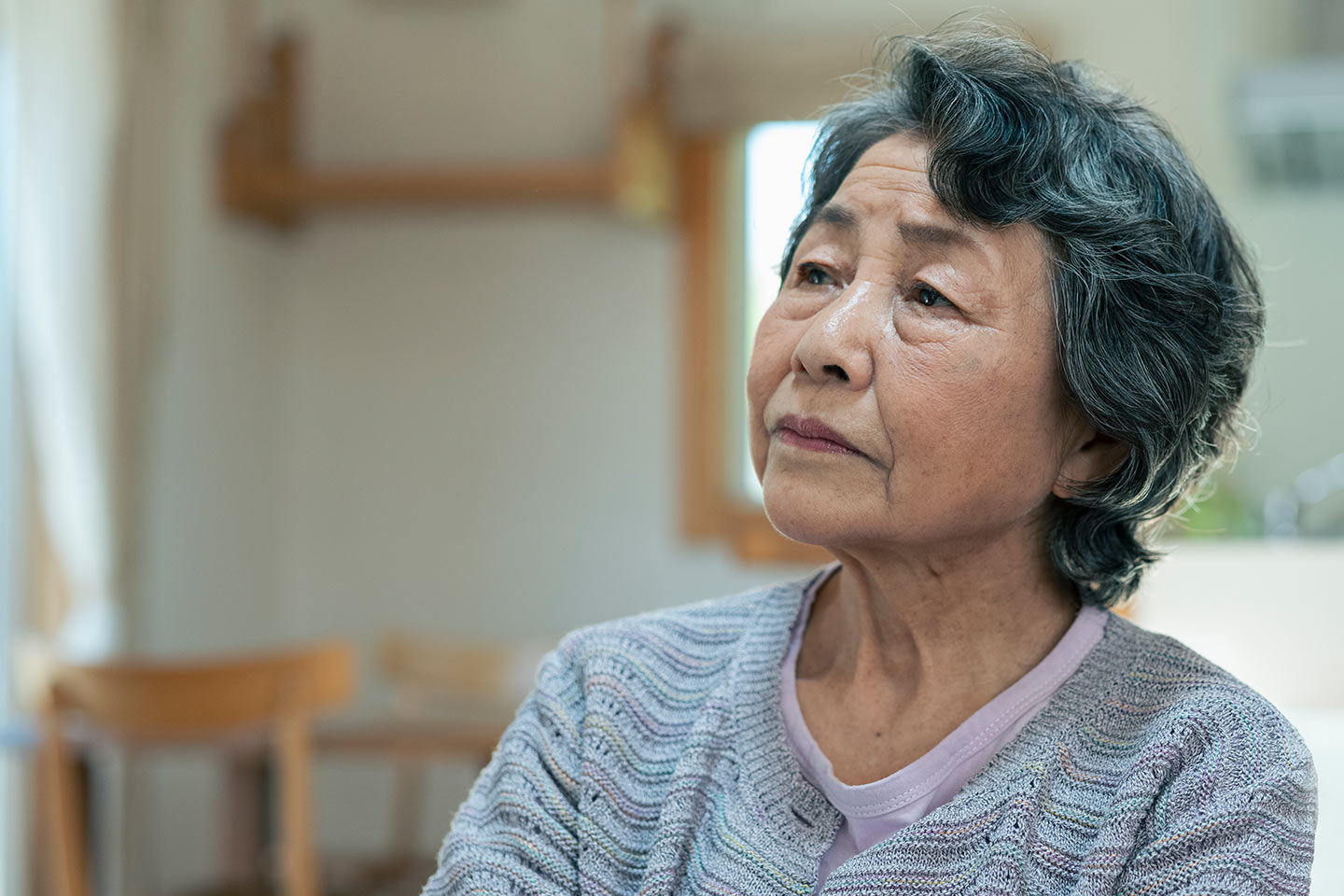 Photo of woman sitting in a light filled kitchen