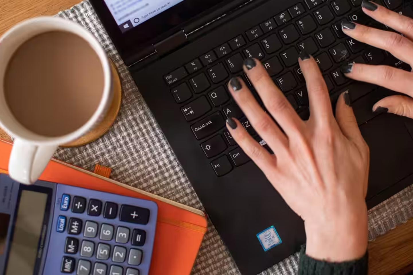 Photo of hands with black painted nails on a keyboard