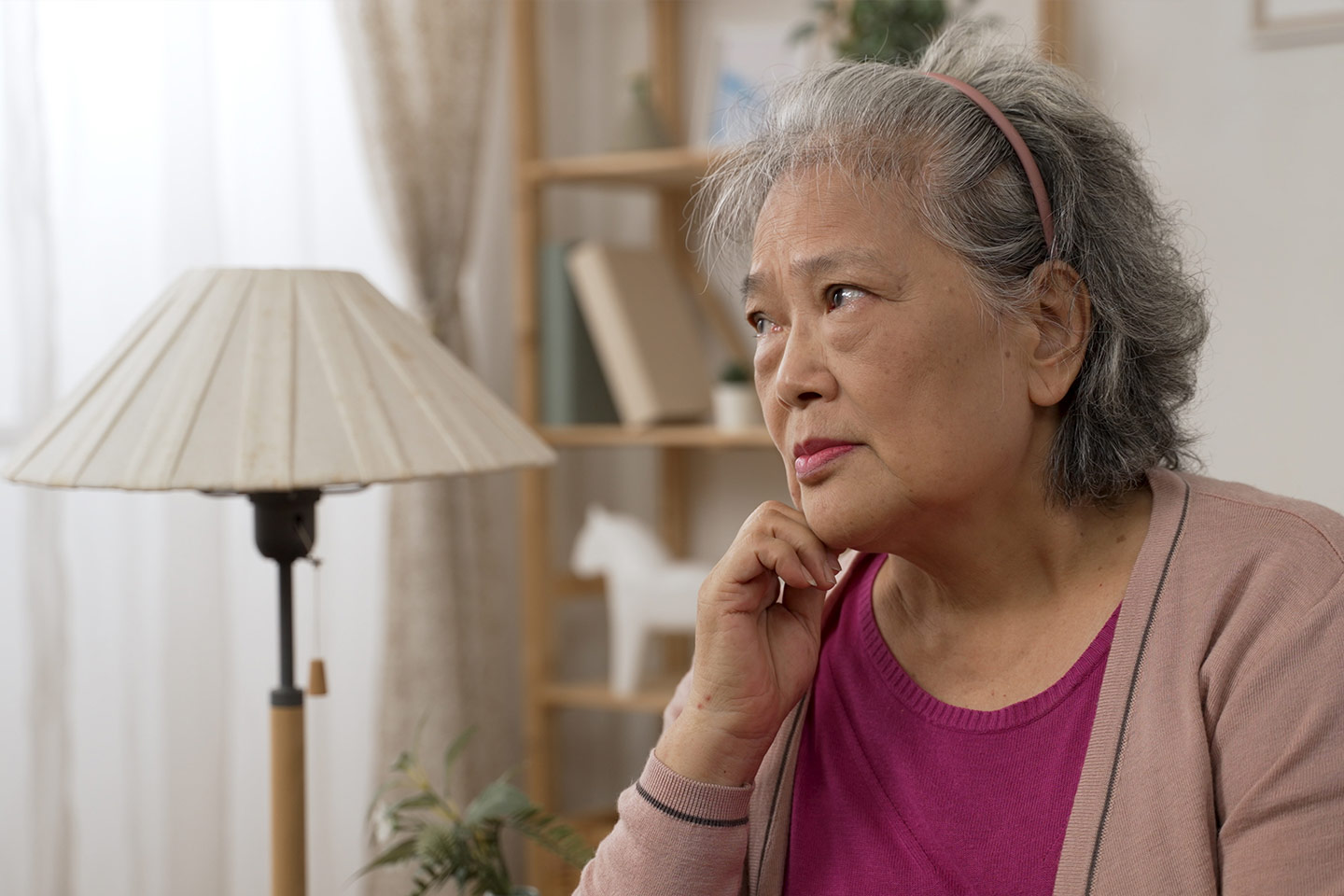 Photo of a woman in a fuchsia blouse and dusty pink cardigan