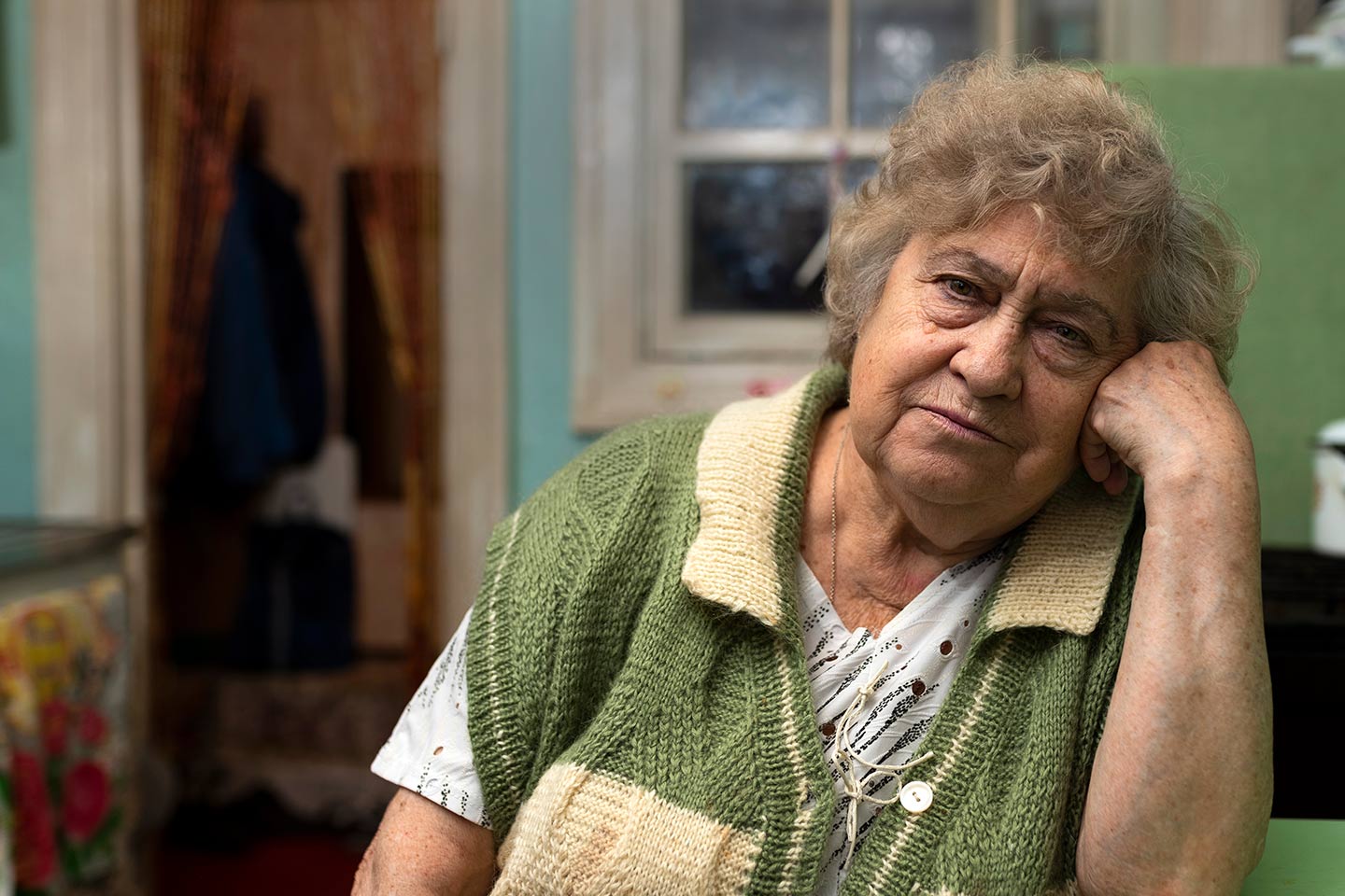 Photo of a woman in a hand knitted green and cream vest