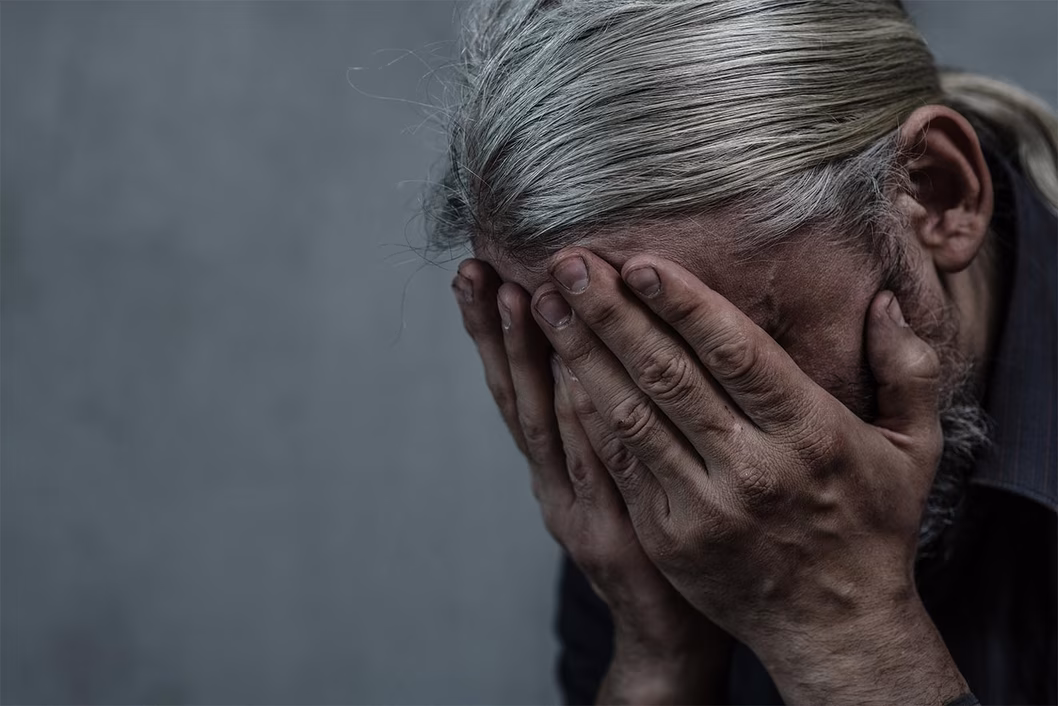 Photo of a person with their face in their hands