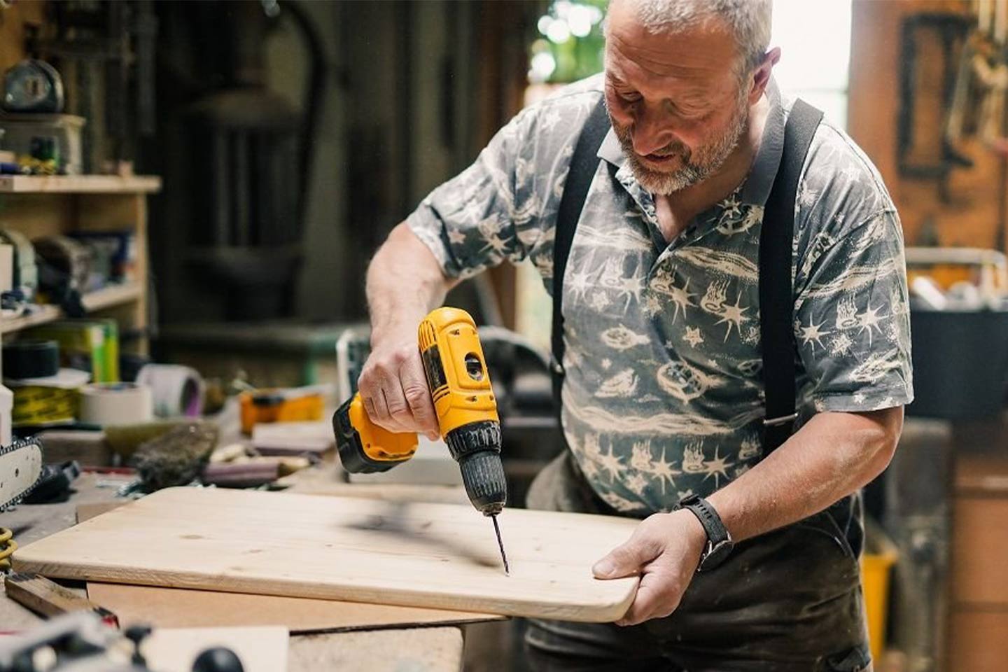 Photo of man using a drill in a workshop