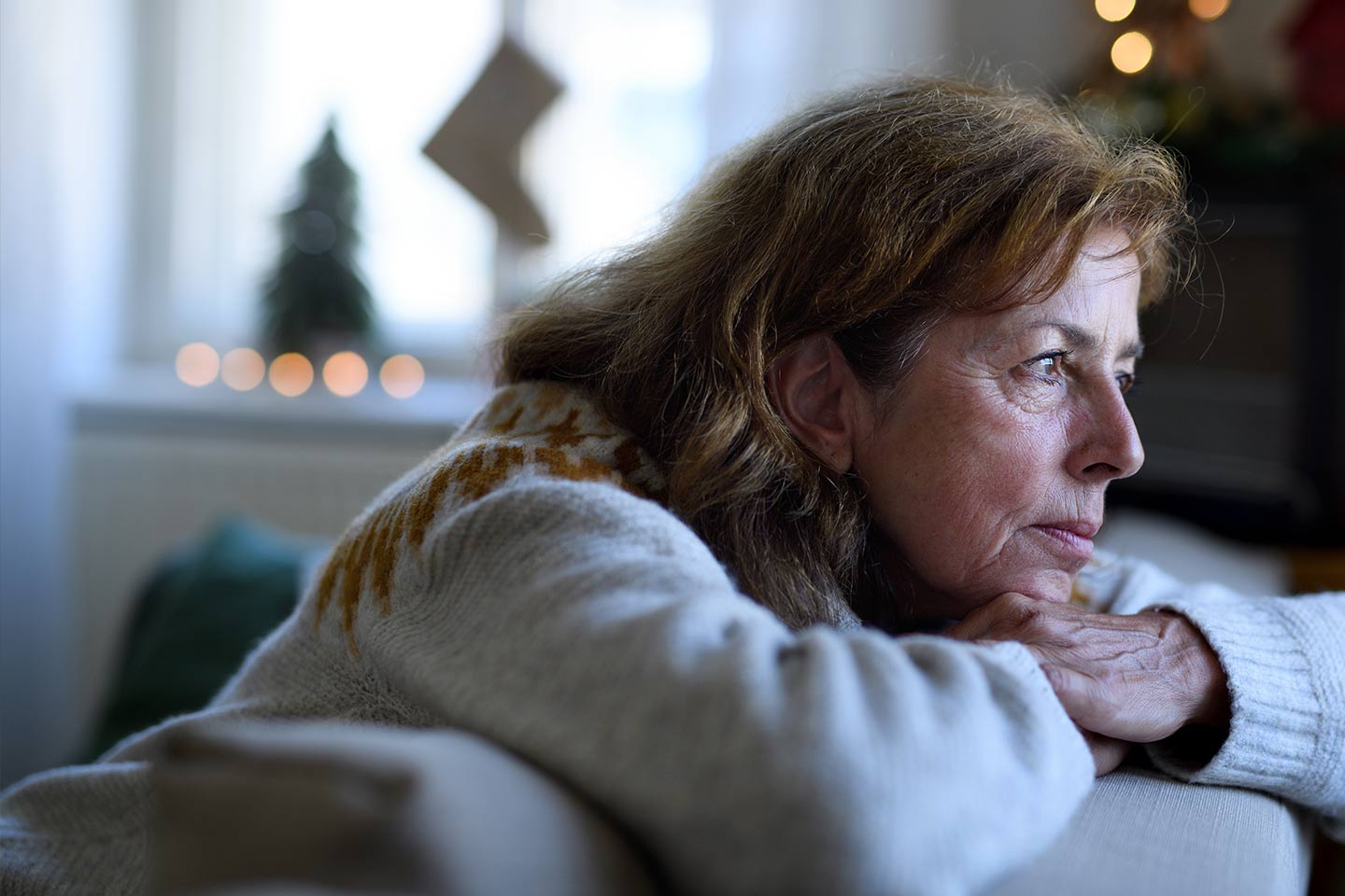Photo of a woman leaning over the back of a sofa